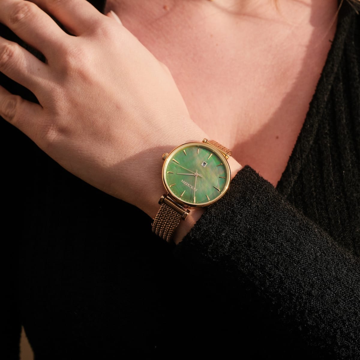 "Sunnyside" watch with a nacre face and gold mesh band, showcasing elegant style.