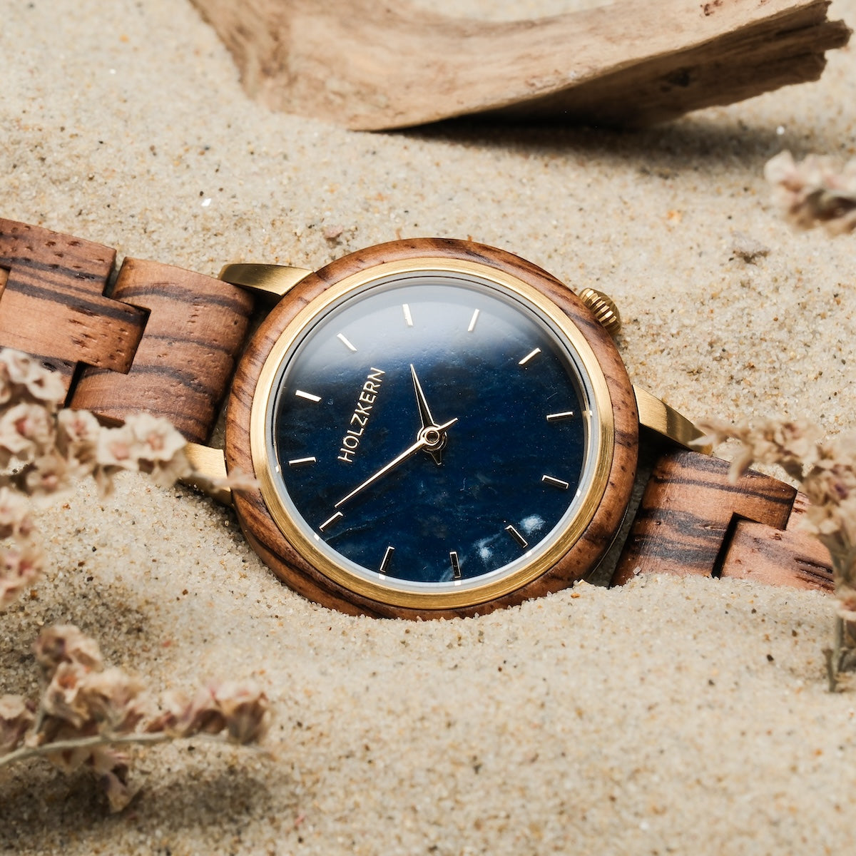 "Balos" watch featuring Zebrawood and Marble with an elegant design style on sandy background.