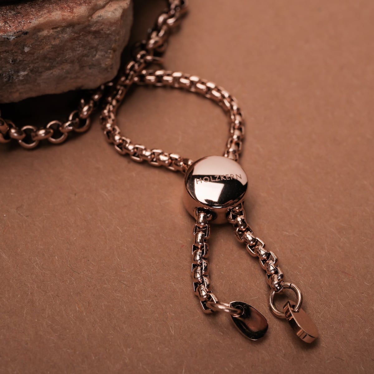 "Leave", un elegante accessorio a catena con accenti di noce e una finitura lucida.