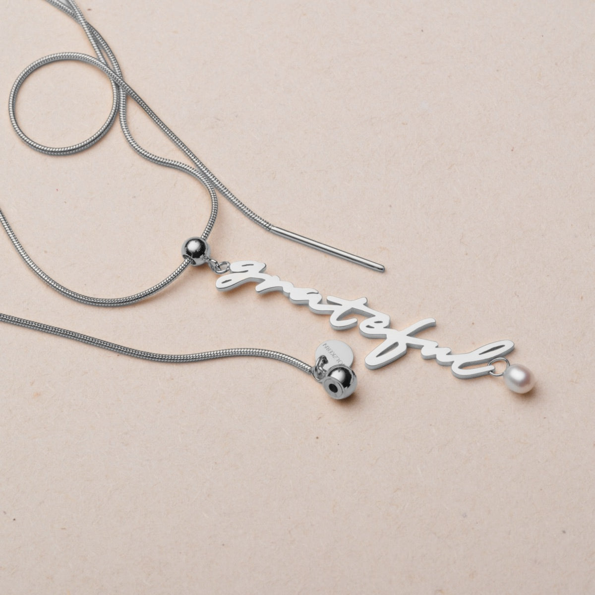 Collana "Grateful-Charm" con perle eleganti e argento, caratterizzata da un delicato fascino e da un design elegante dello script.