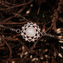 "Composition Gem Bracelet" - Elegant bracelet featuring a moonstone centerpiece with rose gold accents, styled against a natural backdrop.