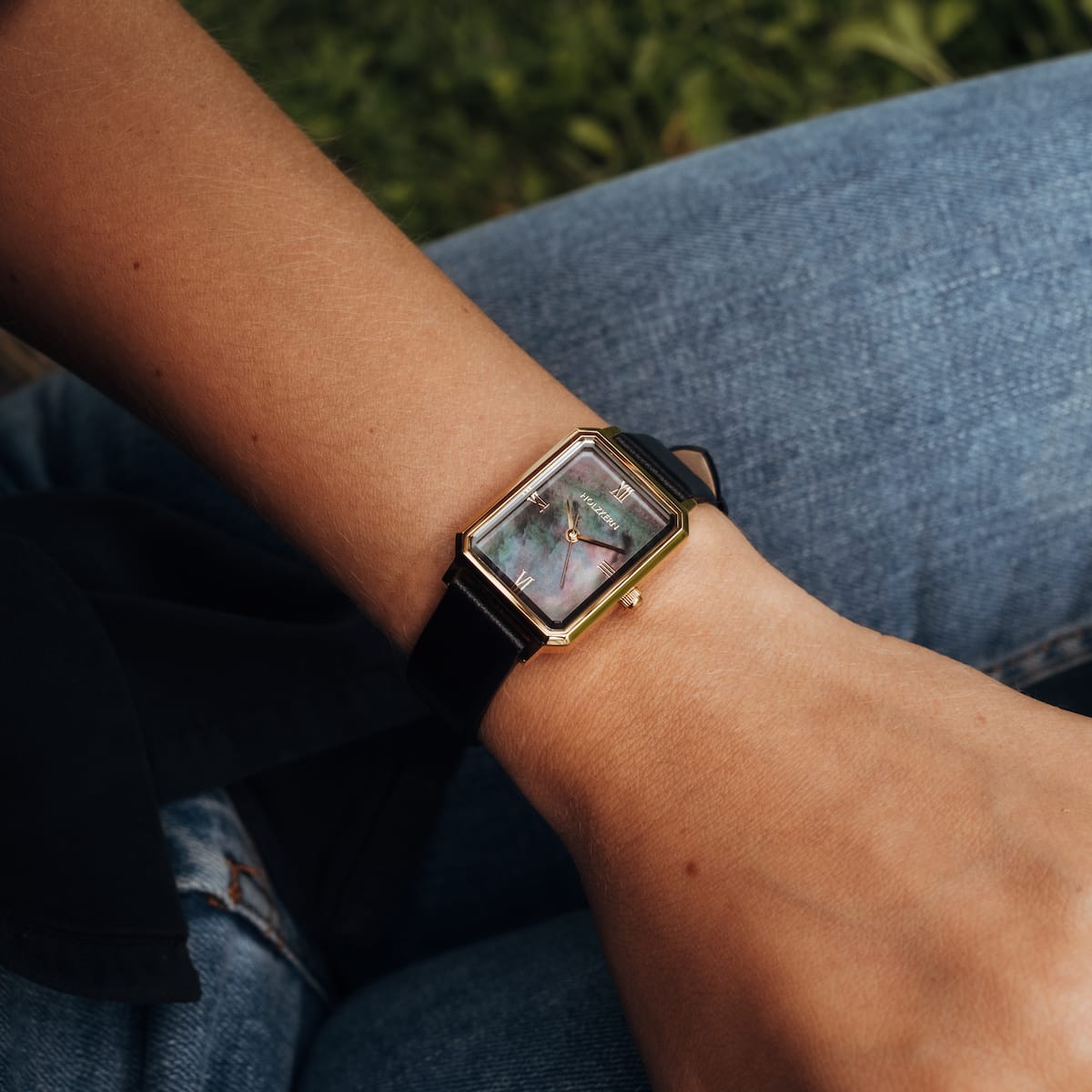 "Auctoritas" watch, featuring a nacre dial and gold accents, worn on the wrist with a sleek, contemporary style.