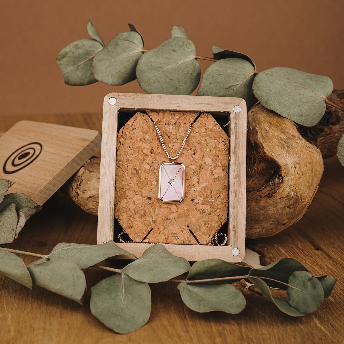 Elegante collana con dettagli in oro rosa e grigio con uno stile sofisticato in un ambiente naturale.