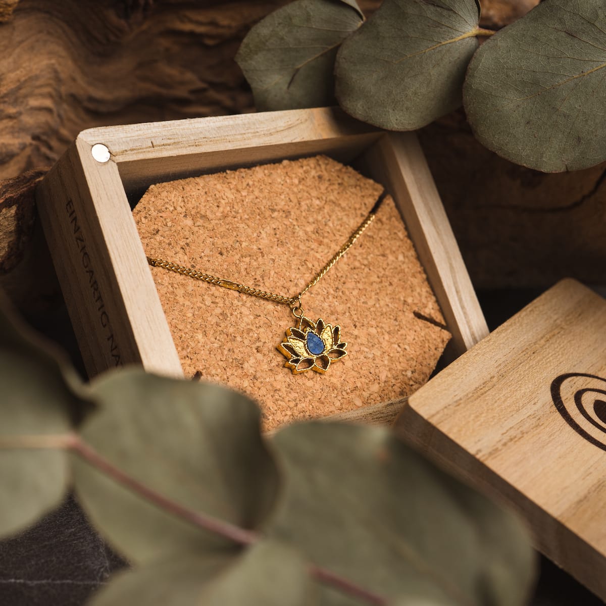 "Collana di equilibrio": Elegante collana in oro con un centrotavola Lapis Lazuli, in vetrina in una scatola di legno rustico.