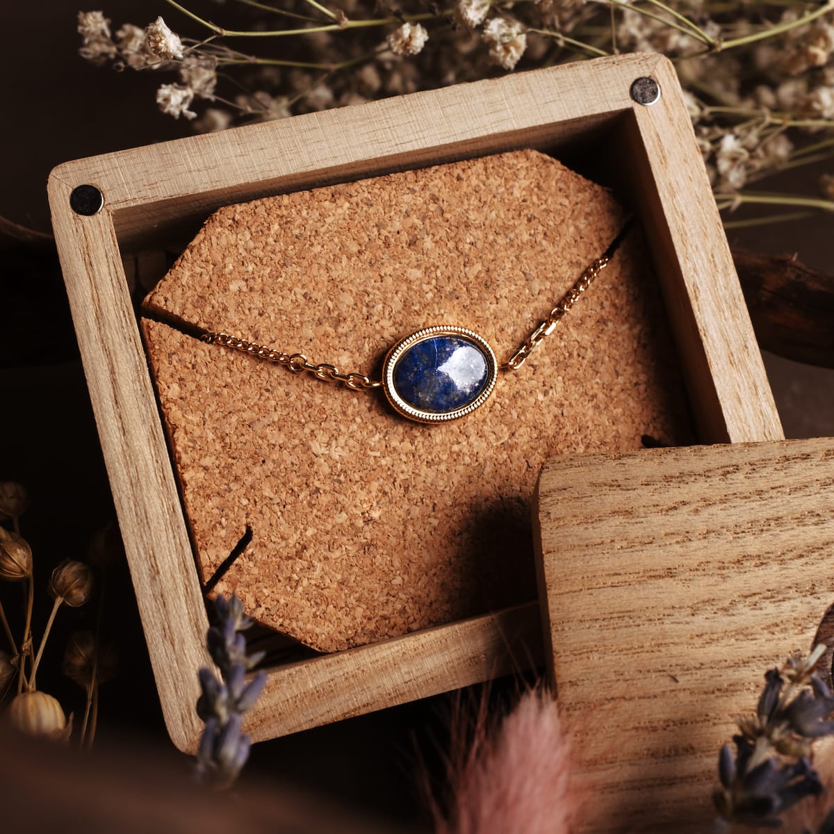 Bracciale "Mirror" con un lapis lazuli in pietra in oro, visualizzato in un elegante scatola di legno.