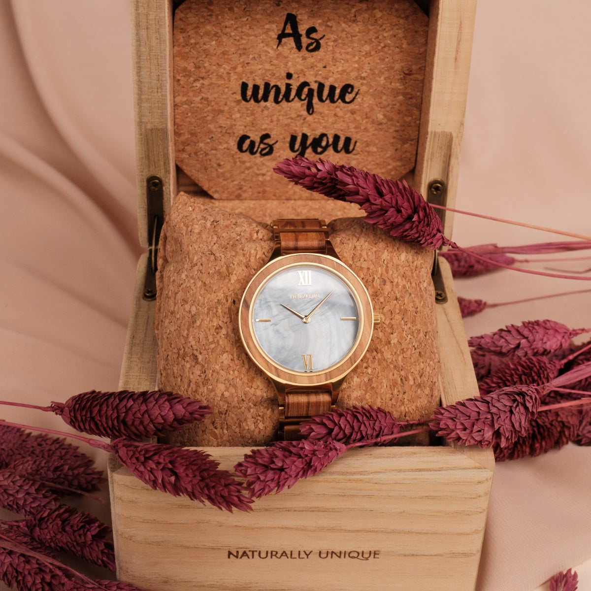 Orologio "Capri" con fascia in legno e quadrante nacre, elegantemente esposto in una scatola rustica con accenti floreali.