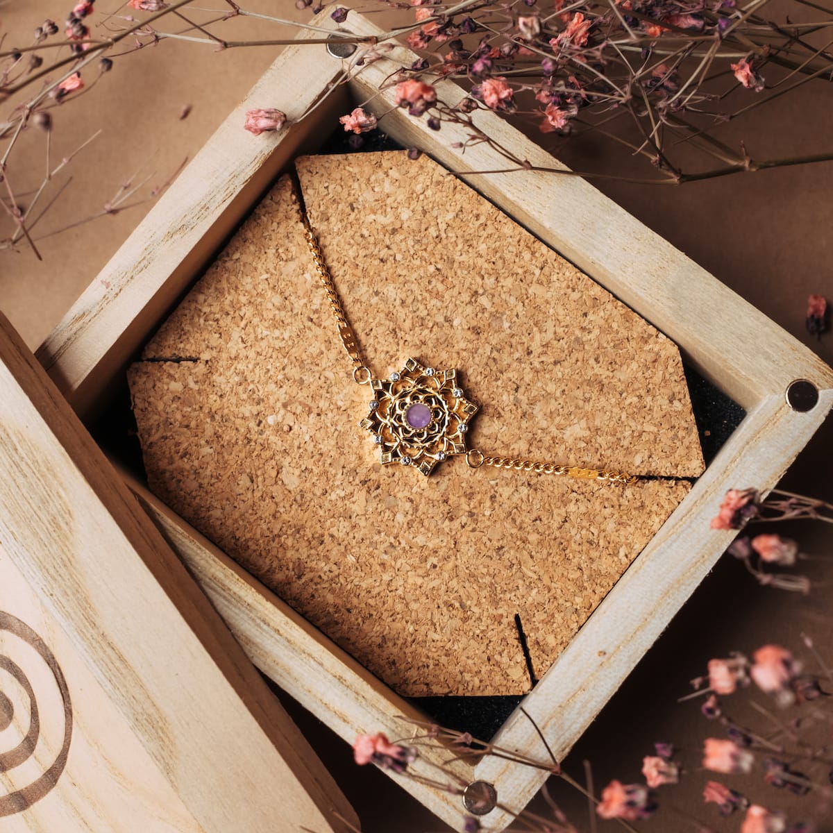 Bracciale "Aphonia" con pietre ametiste e accenti d'oro, esposto in un elegante scatola di legno.