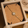 "Composition Gem Bracelet", an elegant bracelet featuring moonstone and gold, displayed on a cork background.