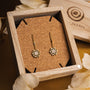 "Composition Gem Earrings" - elegant moonstone and gold earrings in a wooden box.