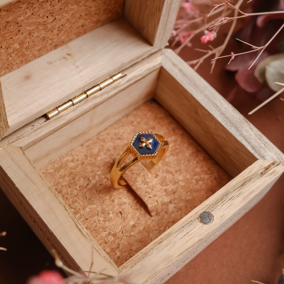 "Spectral Ring" - Elegante anello in oro con dettagli blu nacre, presentato in una scatola di legno.