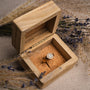 "Pixa Ring" ring in rose gold with nacre detail, presented in a rustic wooden box with a vintage aesthetic.