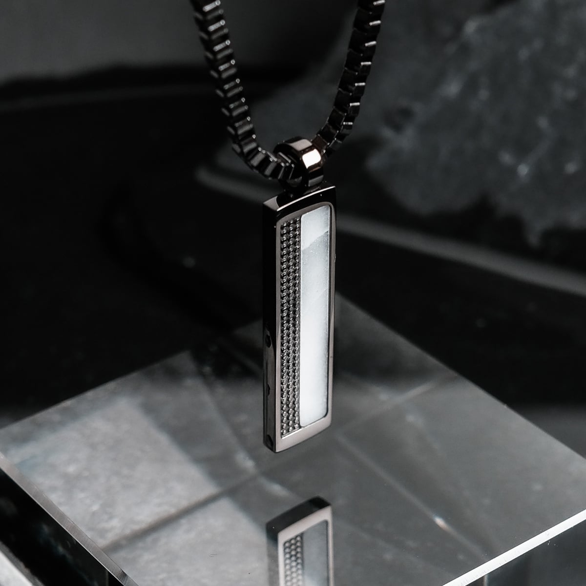 Collana "Planarity Collana" presenta un design elegante e moderno con elementi in marmo e grigio scuro.