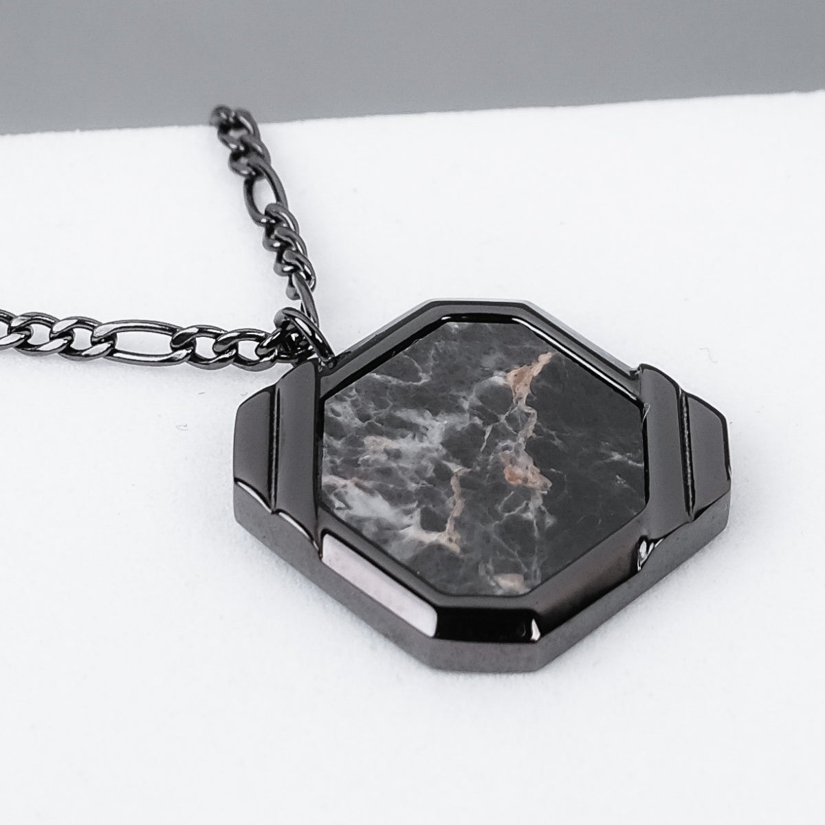 Collana "Scalar" con un ciondolo grigio scuro esagonale con intricati motivi marmo-come e una catena elegante.