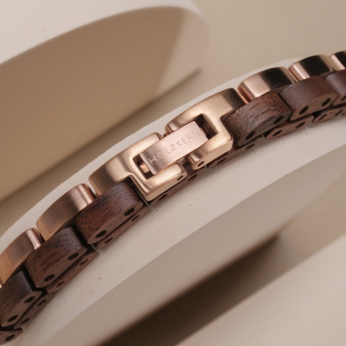 "Duet", un elegante bracciale con accenti in legno di noce e oro rosa, presenta uno stile sofisticato e un'artigianato.