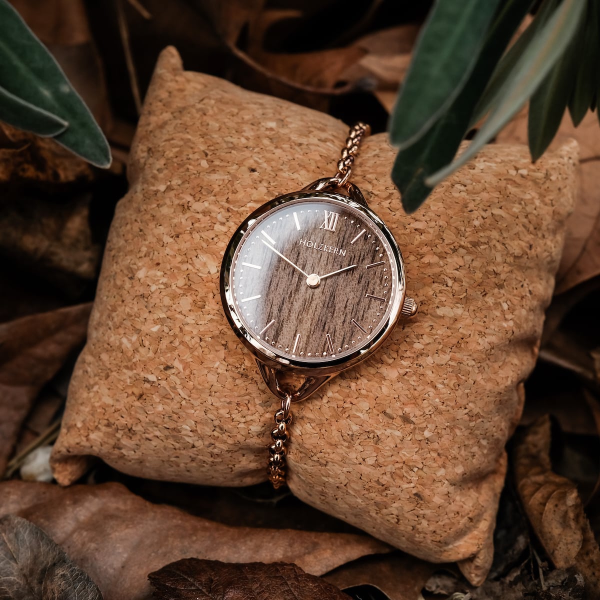Orologio "Blissed" con accenti in noce e oro rosa, in stile su uno sfondo naturale con toni terra.