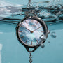 Orologio "Brighter" con stile nacre e argento, sommerso in acqua.