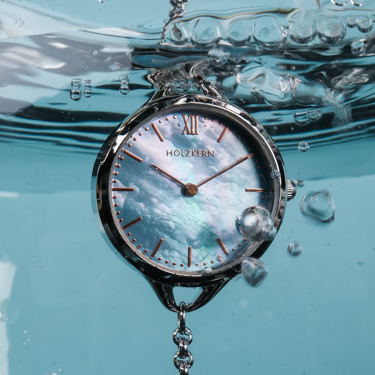 Orologio "Brighter" con stile nacre e argento, sommerso in acqua.