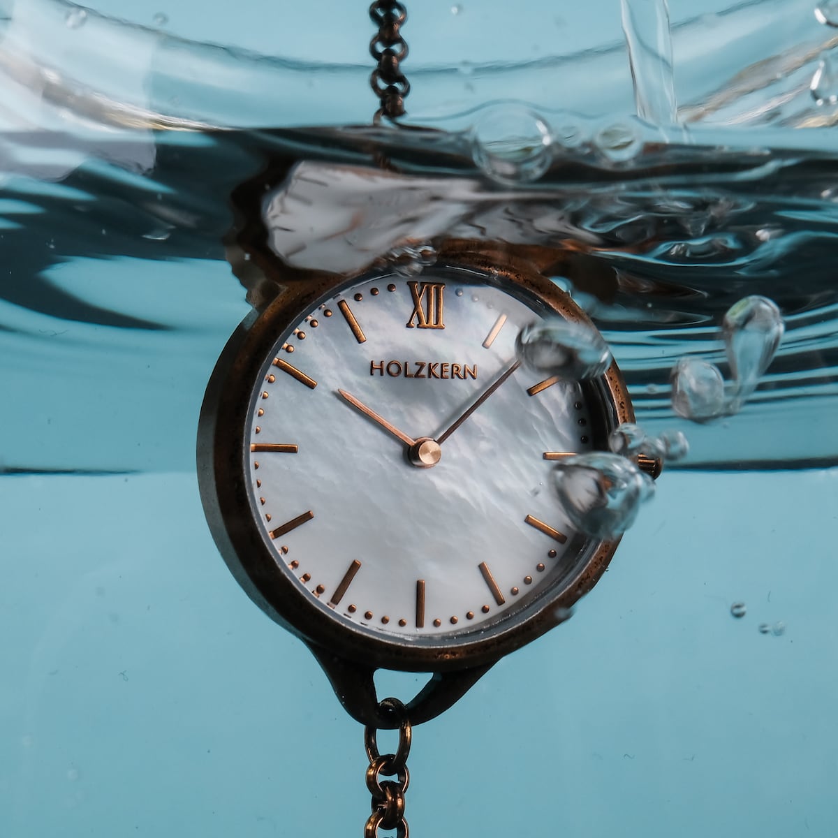 "Touching" watch with nacre face and antique copper finish, submerged in water.