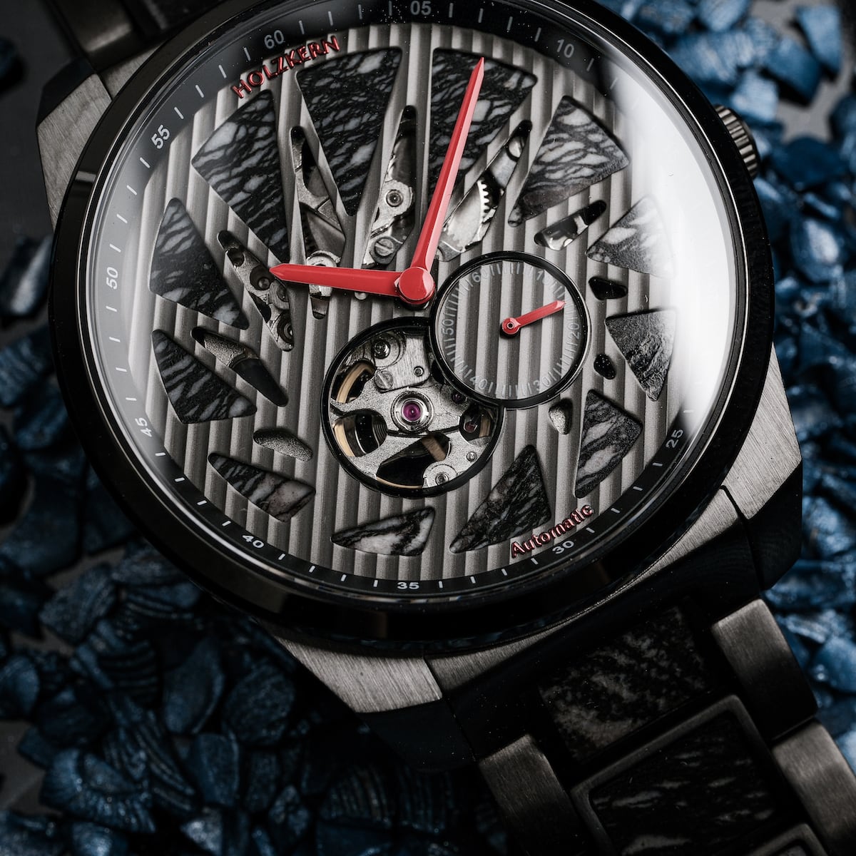 "Pacemaker wristwatch with marble accents and intricate design on a textured dial backdrop."