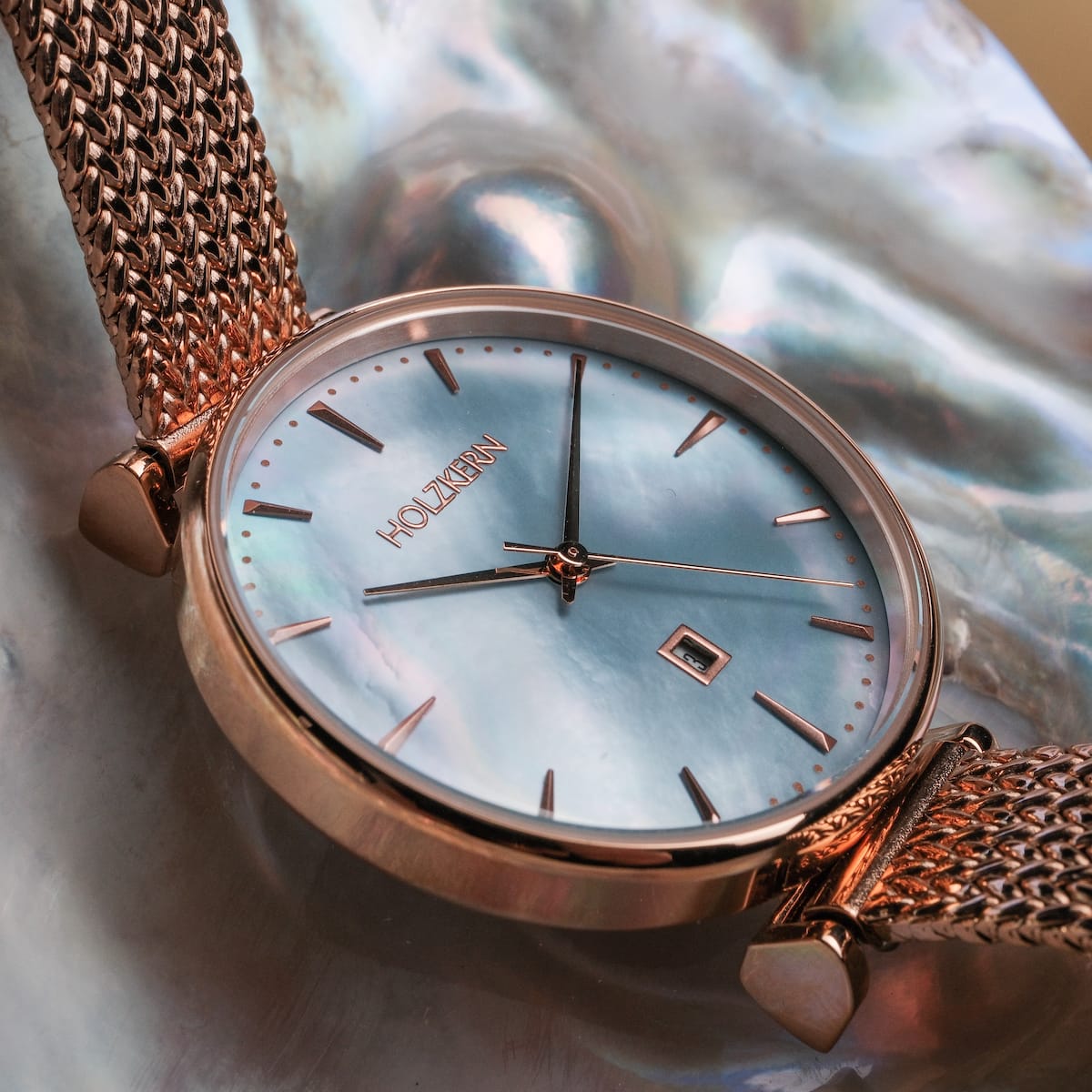 L'orologio "Chitchat" presenta un quadrante nacre con accenti in oro rosa e una fascia in rete per un look elegante e elegante.
