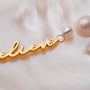 "Believe-Charm", un fascino con script e perle d'oro, che mostra eleganza e raffinatezza.
