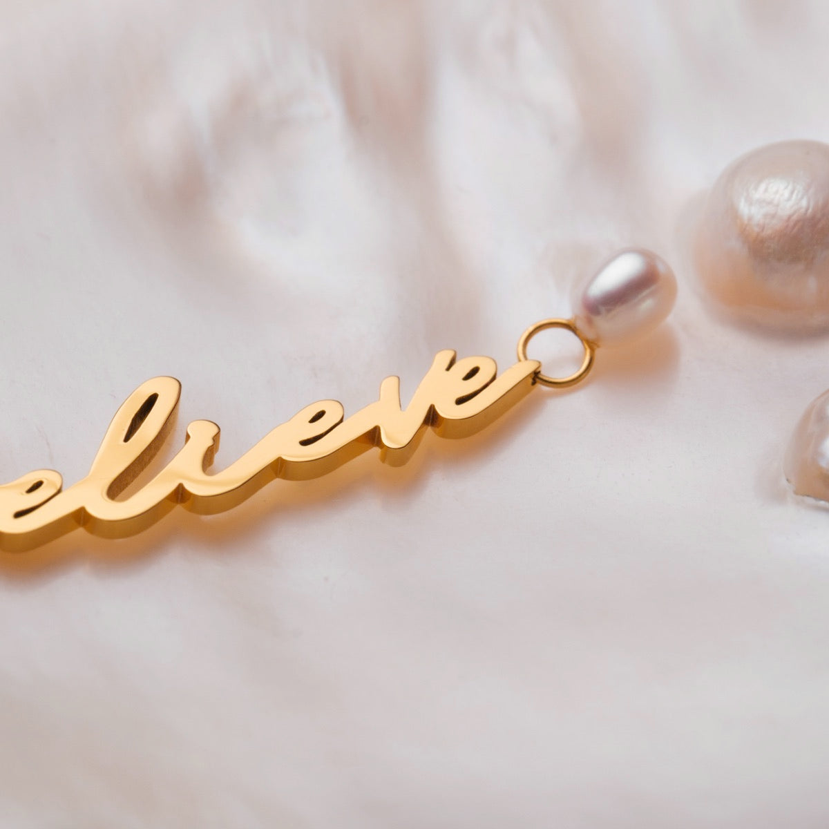 "Believe-Charm", un fascino con script e perle d'oro, che mostra eleganza e raffinatezza.
