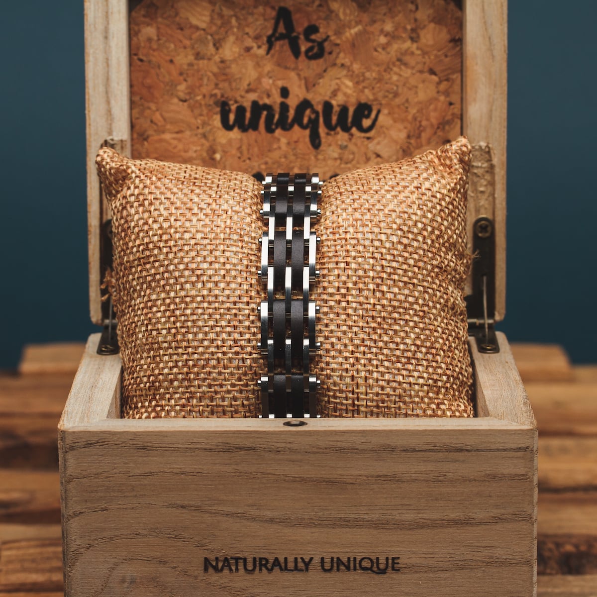 "Adagio", a maple and silver watch, showcases classic elegance in a rustic wooden box with woven cushion.