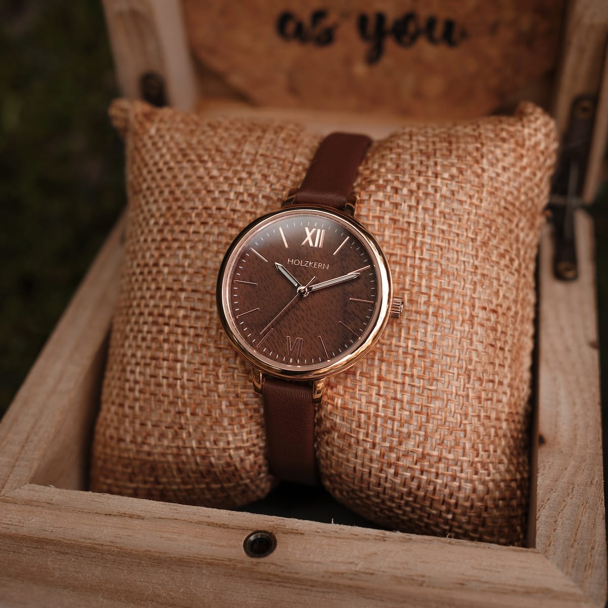 "Shirin", elegant watch in walnut/rose gold with a classic leather band, displayed in a rustic box.