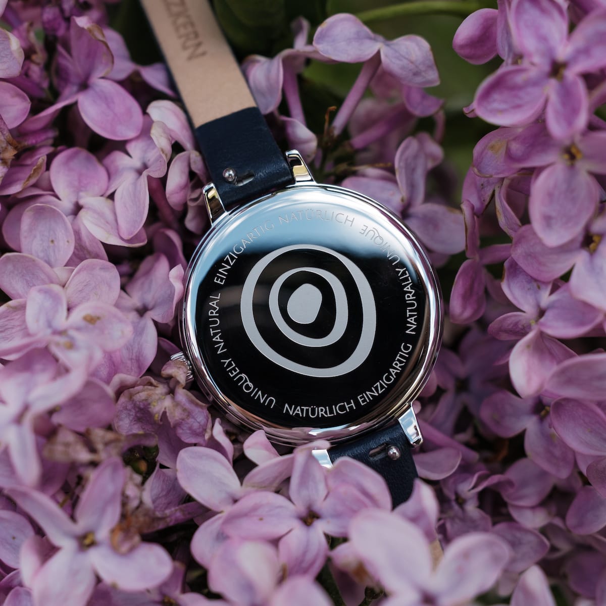 "Teresa", a stylish watch featuring lapis lazuli and silver against vibrant purple flowers.