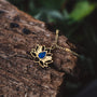 Collana "Balance", con un design loto in oro con accento lapis lazuli, elegantemente poggia su legno strutturato.