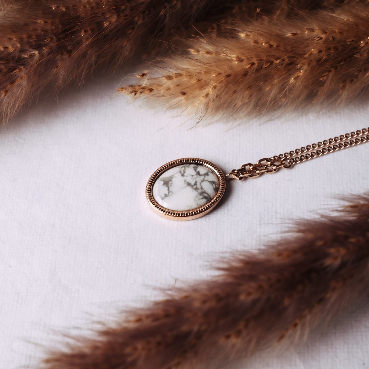 La collana a specchio presenta un design rotondo elegante in eleganti accenti in oro turchese e rosa.