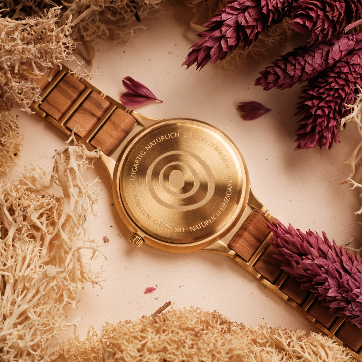 Orologio "Capri", con un legno naturale e uno stile oro, elegantemente circondato da botanici secchi.