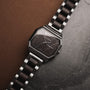 Orologio "Kéré", design esagonale elegante con accenti in legno di acero scuro e acciaio.