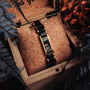 "Adagio" bracelet with a marble and gold design in an elegant wooden box, surrounded by foliage.