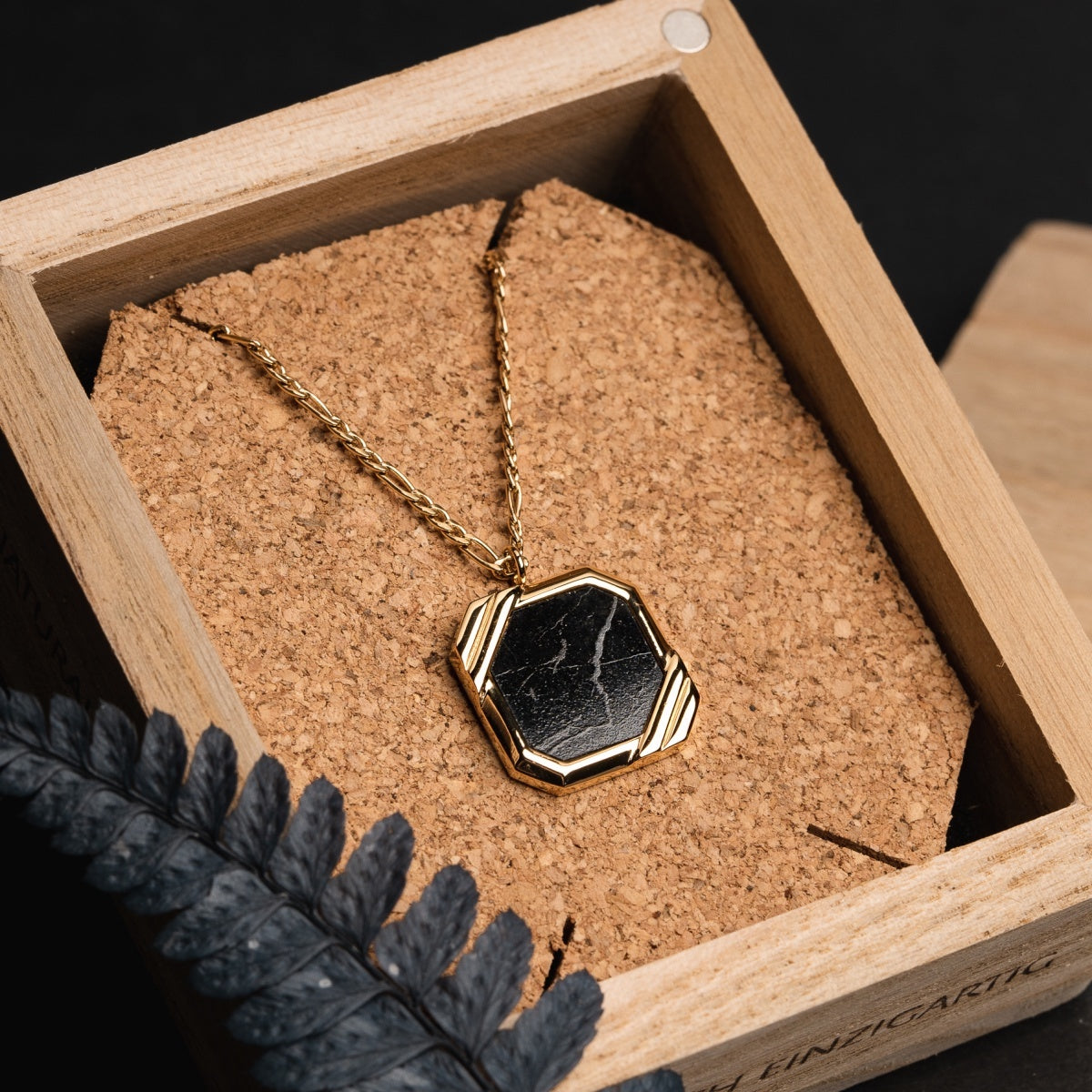 "Collana in legno", una collana in oro e marmo con un elegante design a sospensione esagonale.