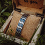 Bracciale "Baritone" presenta un elegante design sodalite e argento, elegantemente esposto in una scatola di legno rustico.