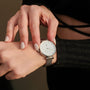 "Piccolo" wristwatch featuring a nacre face and silver mesh strap, showcasing a sleek and elegant design.
