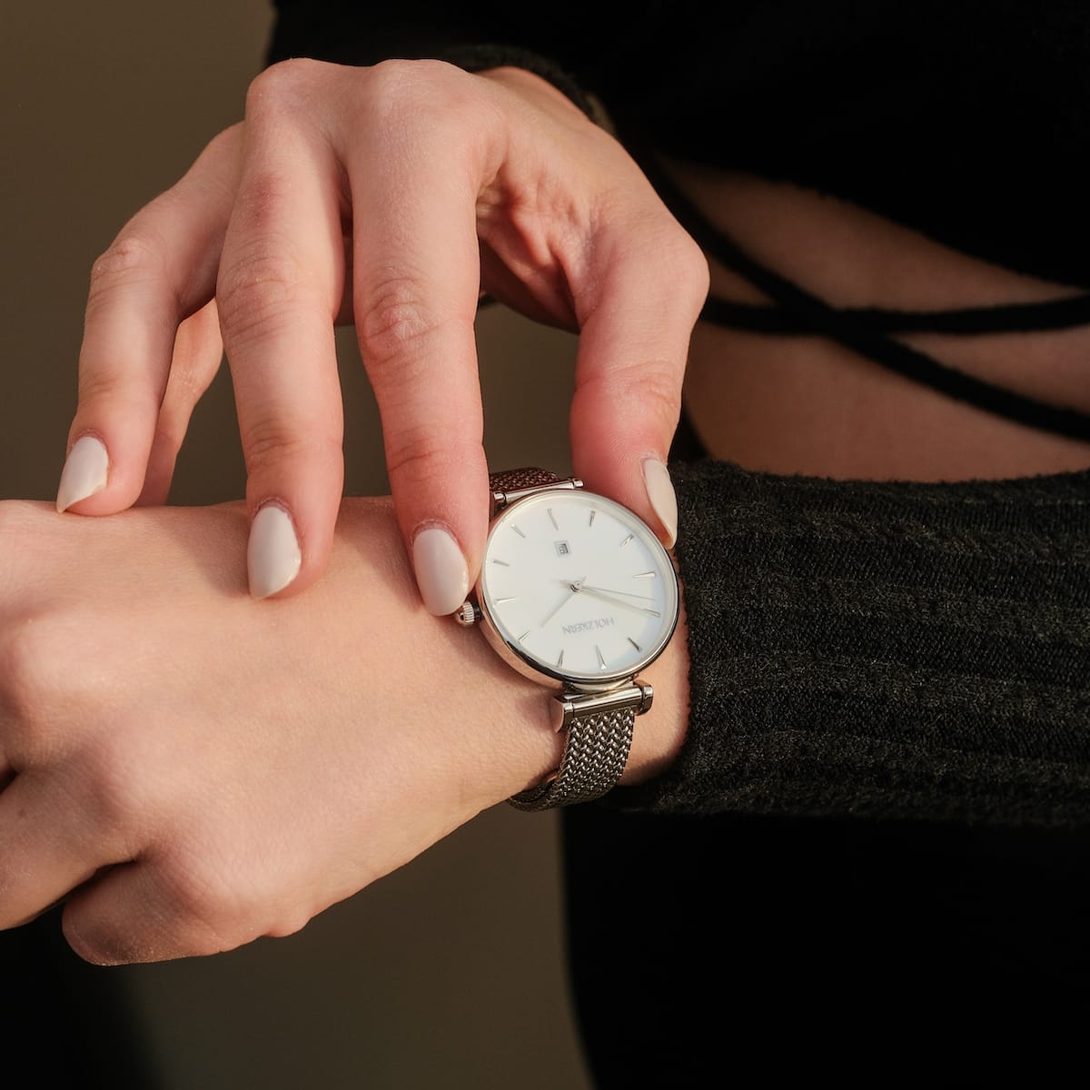 "Piccolo" wristwatch featuring a nacre face and silver mesh strap, showcasing a sleek and elegant design.