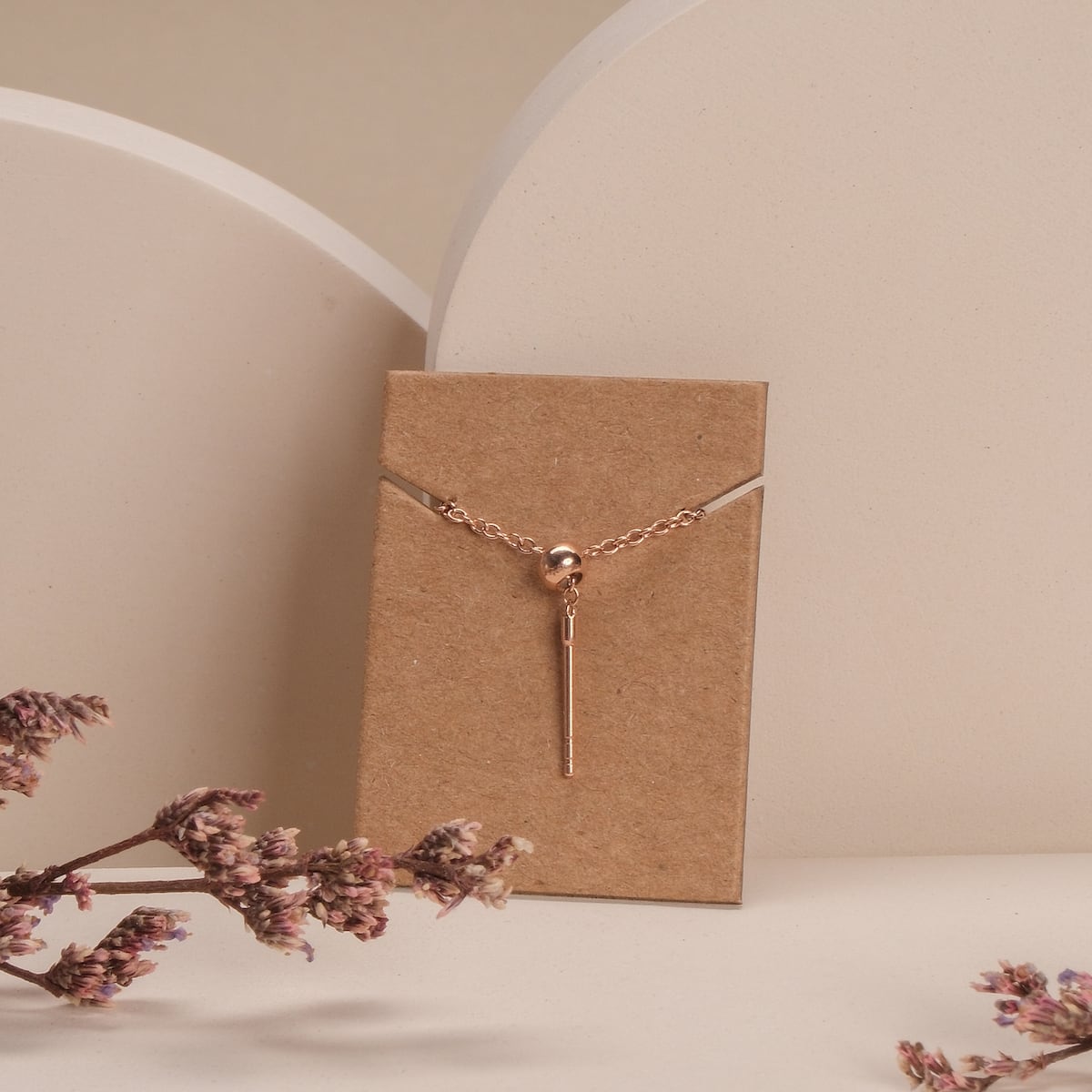 "Jewelry Extender", a rose-hued jewelry extender, elegantly displayed with a minimalist style.