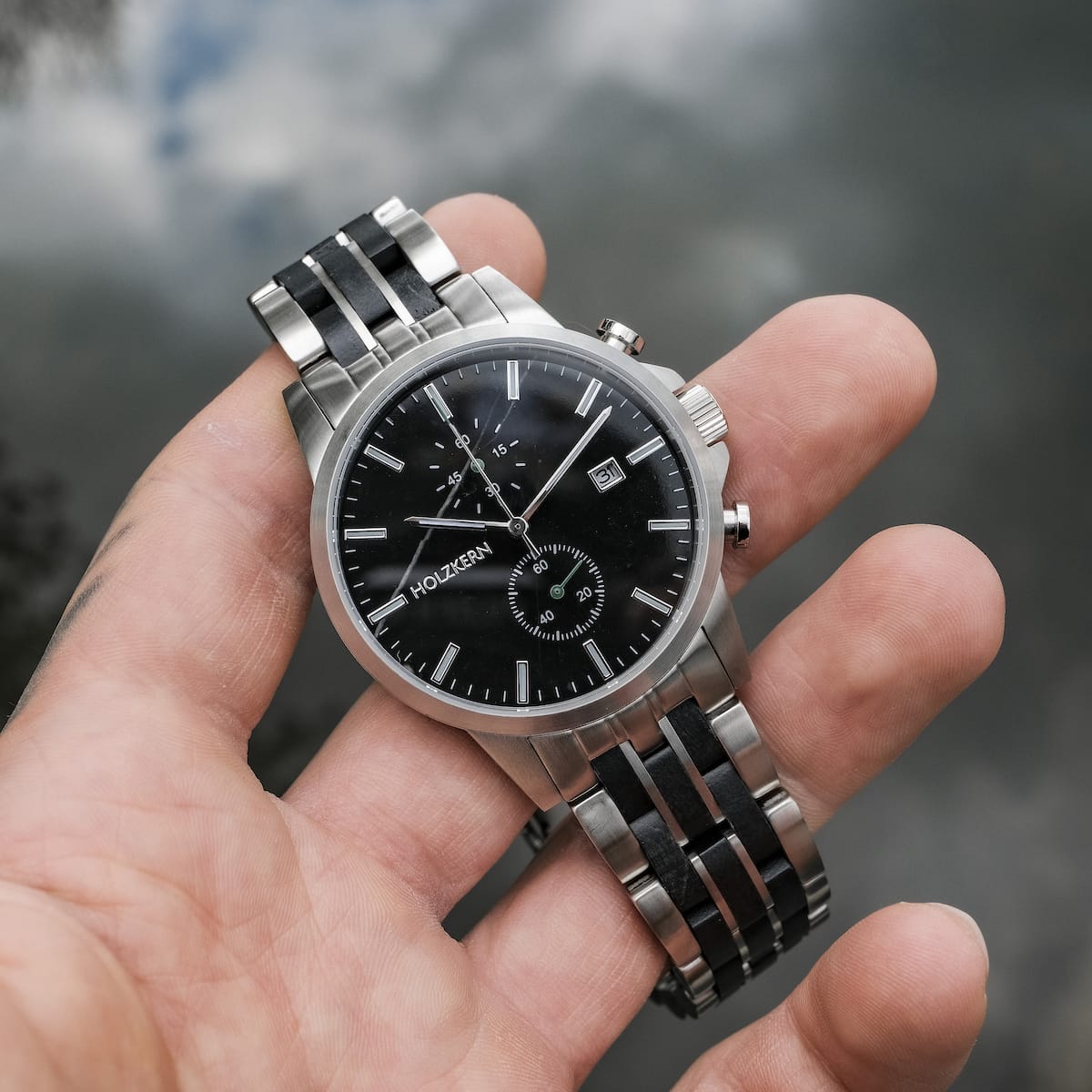 "The Observant watch features a sleek black dial and metal strap, with a classic and elegant style."