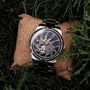 "Spikes watch, featuring Lapis Lazuli and Maple, with a modern, textured design against a natural green backdrop."