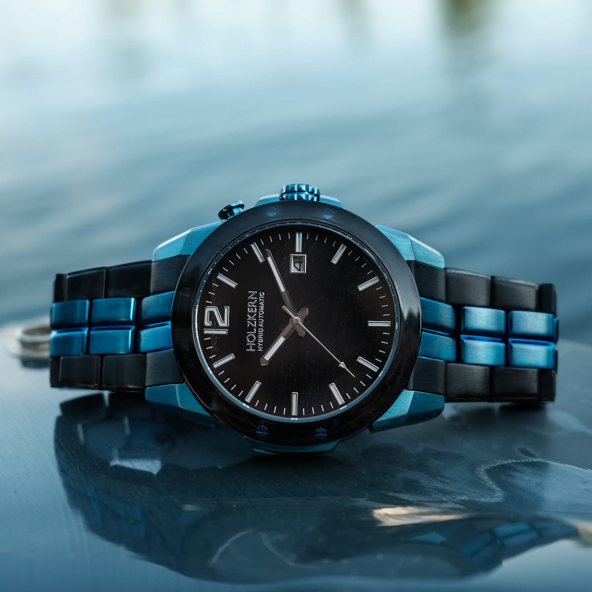 L'orologio "Glaciersurge" presenta un design elegante con l'occhio lucido di Hawk e dettagli Maple, impostato su un tranquillo sfondo d'acqua.