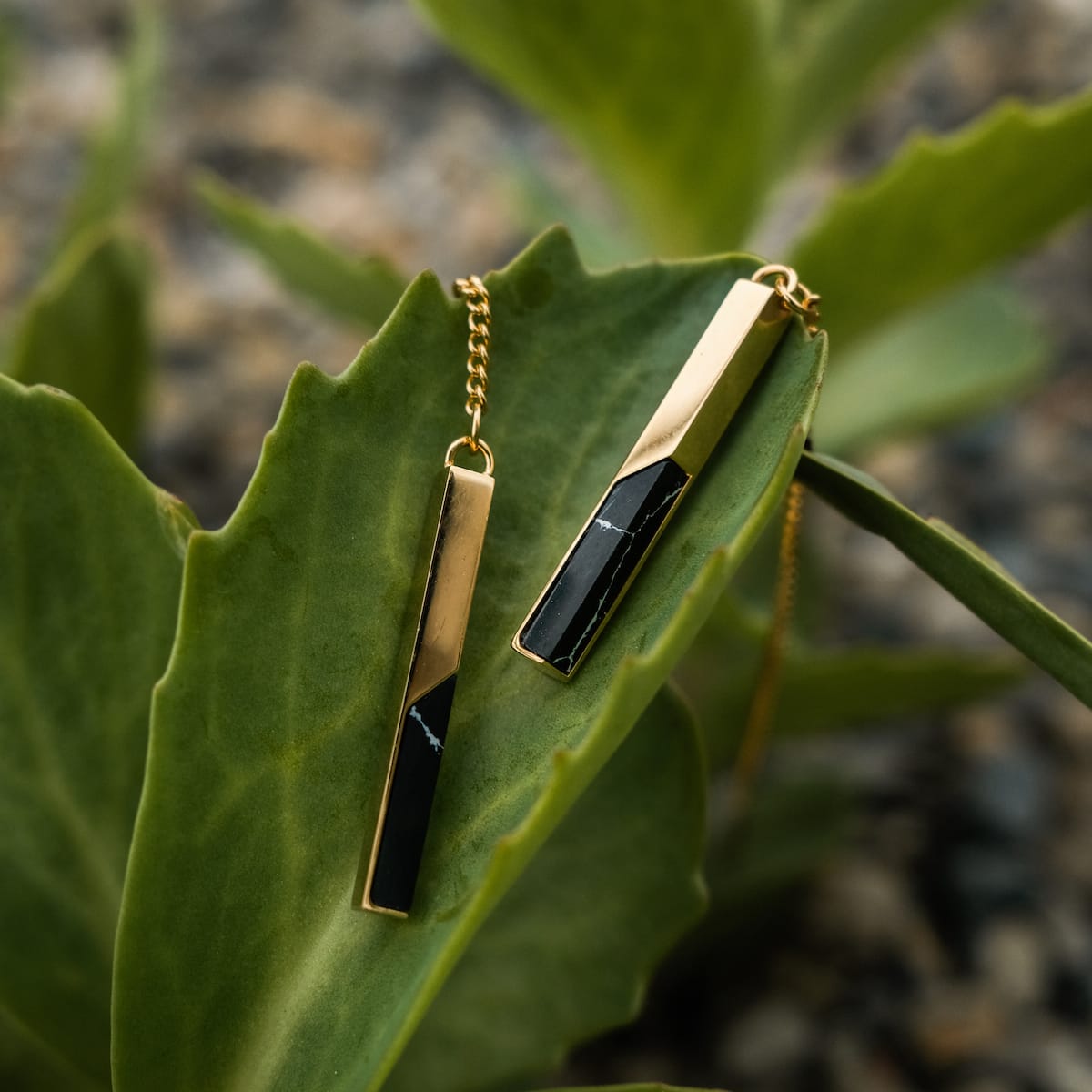 "Campania Earrings: elegant earrings featuring marble and gold accents on a natural backdrop."