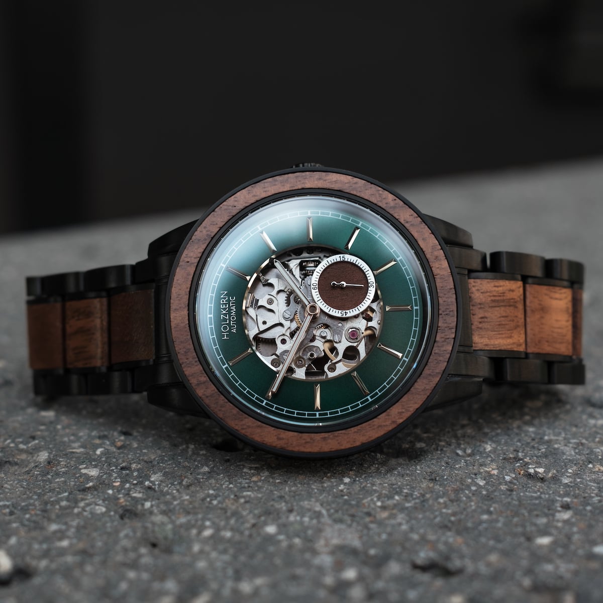 Orologio "Sigiriya" con corpo in noce e cinturino dal design meccanico sofisticato e quadrante verde.