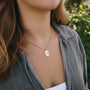 "Collana Aquarell", un elegante collana con un design in oro rosa e grigio, indossato da una persona all'aperto in un outfit casual.