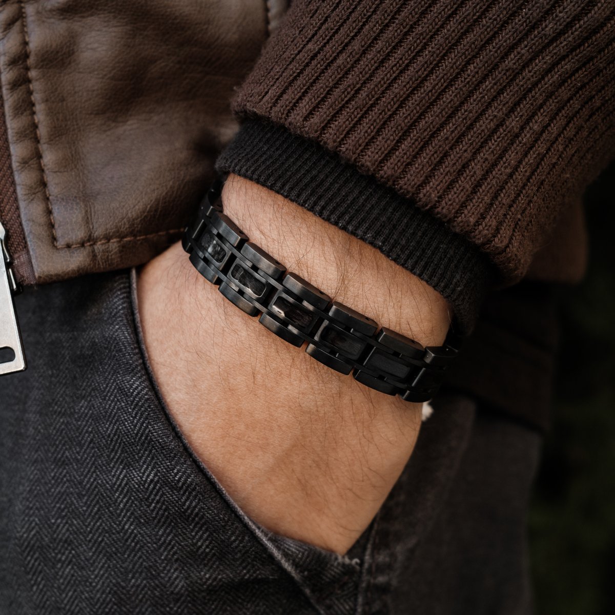 Bracciale "Tremolo" con un elegante acero e un design grigio scuro, indossato con stile con abbigliamento casual.