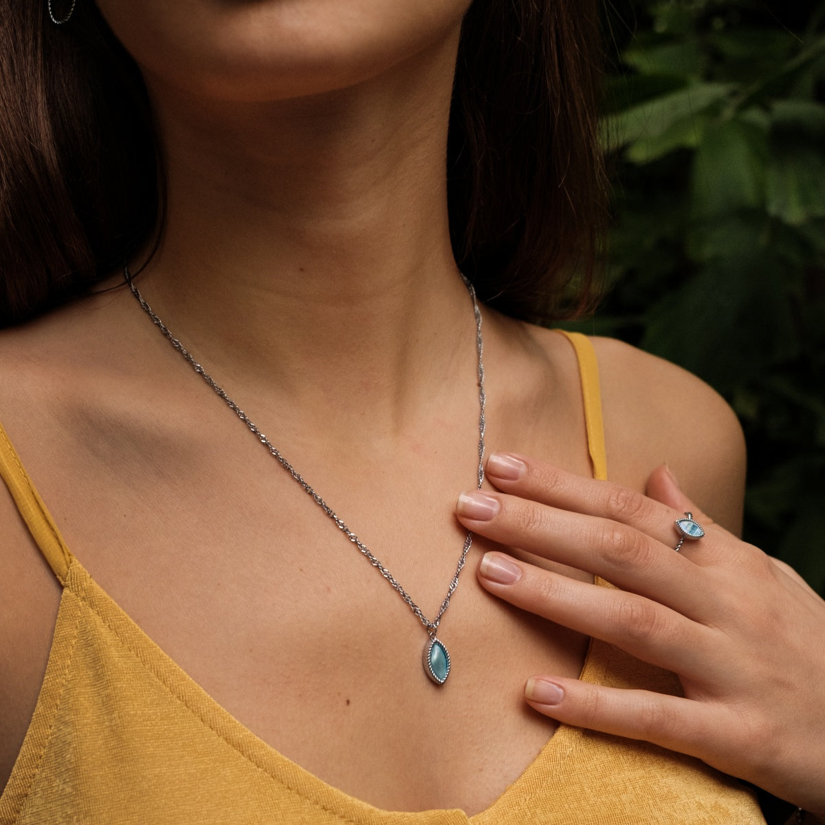 "Collana Visuale", una collana elegante e argentata, mostrata elegantemente su uno sfondo vibrante.