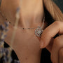"Composition Gem Necklace" necklace featuring a silver moonstone pendant with a delicate, intricate design.