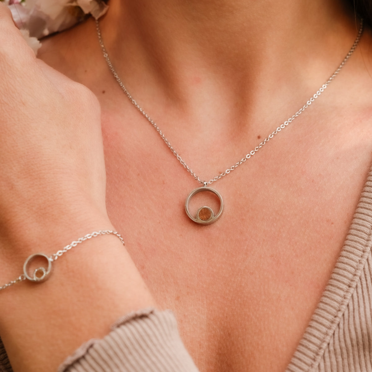 Collana "Pigment Collana" con ciondolo circolare con koa e argento, indossato con un bracciale abbinato per uno stile elegante.