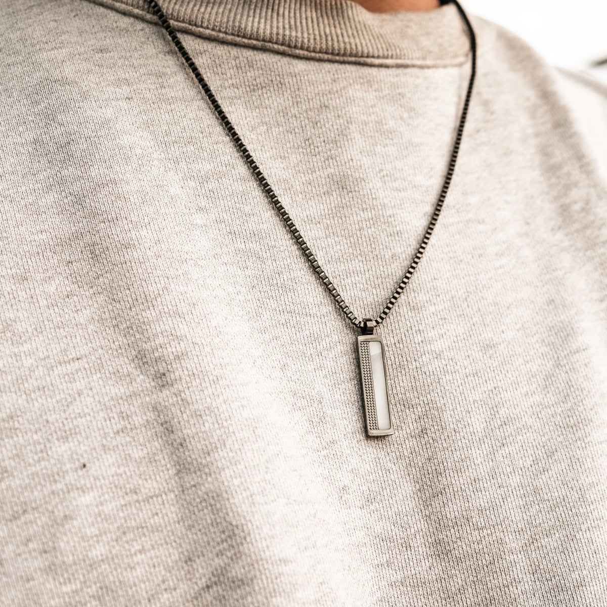 Collana "Planarity Collana" in marmo e grigio scuro, con un elegante e minimalista ciondolo dall'estetica moderna.